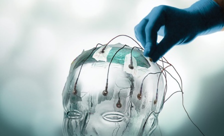 Glass human head with sensors being placed on it.