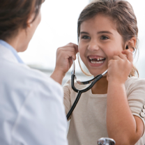 Doctor letting girl use stethoscope
