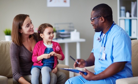 Doctor discussing patient chart with mother and daughter