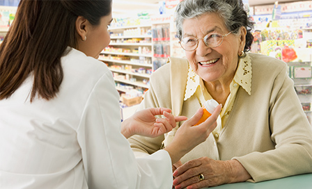Senior Hispanic woman discussing medication with pharmacist