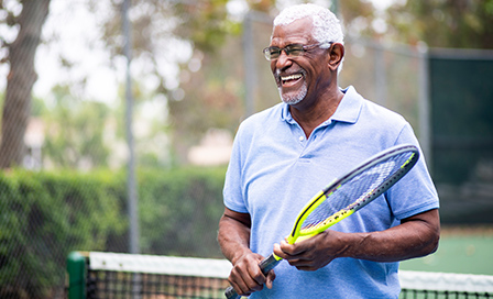 Portrait of a senior black man with a tennis racket