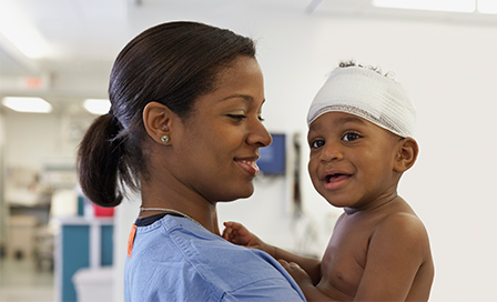 African American medical professional holding baby