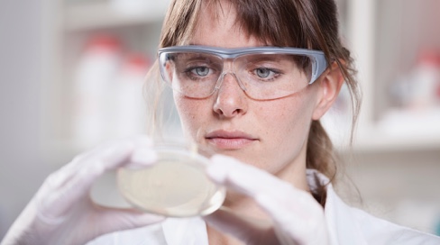 Scientist with petri dish in laboratory